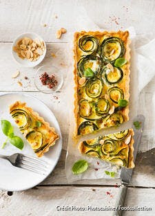 Quiche aux courgettes, baies roses, feta, basilic et amandes torréfiées